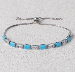 Macro detail of adjustable silver bracelet featuring alternating turquoise and zircon stones