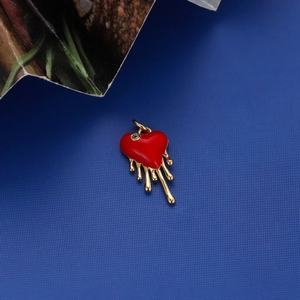 Detailed view of heart-shaped gold-plated pendant with red enamel melting effect and loop