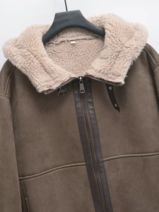 Dettaglio di giacca in pelle scamosciata marrone con fodera in pile e zip metallica