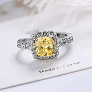 Elegant cushion-cut yellow zircon ring with surrounding halo and pave stones