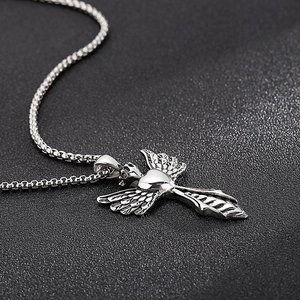 Detailed macro view of silver angel wing pendant with heart element on box chain necklace