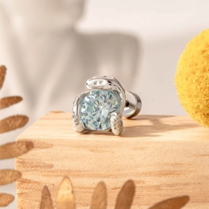 Surgical steel snake stud earring with a blue zircon stone on a natural wood background