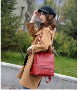 Close-up of red vintage faux leather backpack with stylish striped webbing straps
