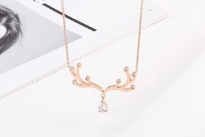 Détail du collier bois de renne en or rose avec un pendentif cristal en forme de poire