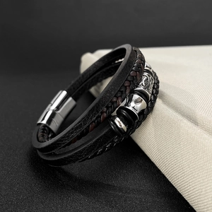 Detail of multi-layer braided leather bracelet with lion head charm and magnetic clasp