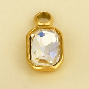 Macro shot of rectangular clear crystal pendant with gold frame and faceted glass surface