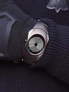Close-up of Y2K silver metal watch with grey dial on black knit sleeve texture