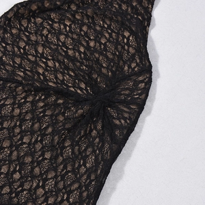 Détail de dentelle noire avec doublure dorée et texture drapée froncée sur la robe