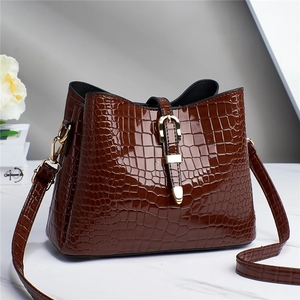 Detail of dark brown faux crocodile leather tote bag with elegant golden clasp lock