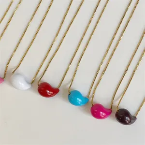 Macro view of multi-color drop pendants on gold stainless steel necklaces in various shades