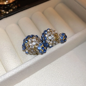 Detailansicht goldfarbene doppelseitige Ohrstecker mit blauen und weißen Kristallen