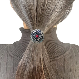 Western cowboy style silver ponytail cuff with embossed floral patterns and red bead
