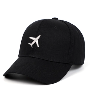 Detailed view of a white airplane embroidery on a classic black cotton baseball cap