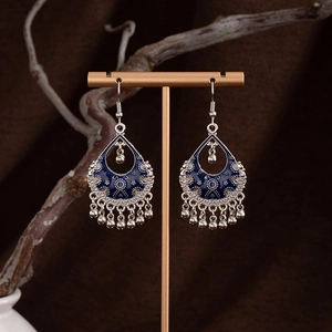 Bohemian teardrop earrings with deep blue enamel and tassels on a vintage stand