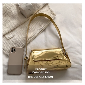 Close-up of golden metallic shoulder bag with smartphone for size comparison
