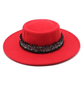 Detalle de sombrero de fieltro de lana roja con cinta de tweed blanco y negro elegante