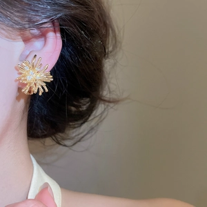 Elegant 18k gold-plated firework stud earring with sparkling zircons shown on model ear