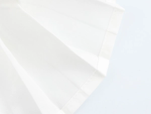 Gros plan de l'ourlet plissé blanc montrant les coutures et la texture du tissu