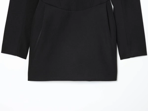 Détails d'une robe blazer noire montrant la texture du tissu et les strass brillants
