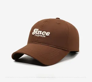 Detail view of the embroidered Since FASHION lettering on this brown cotton baseball cap