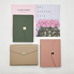Detail of leather notebooks with metallic buckle in green, khaki and pink colors