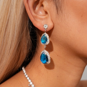 Vue détaillée de boucles d'oreilles de luxe avec cristaux bleu foncé sur le modèle