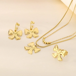 Detailed close-up of 18K gold-plated bow jewelry set with snake chain necklace and ring