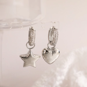 Asymmetric silver earrings with star and heart charms featuring cubic zirconia crystals
