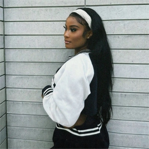 Detail view of a black and white baseball jacket on a model with white headband