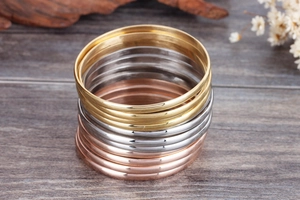 Polished titanium steel stackable bracelets in gold, silver, and rose gold finishes