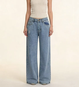 Détail d'un jean taille haute à jambe large bleu clair avec légers effets d'usure