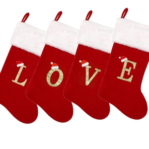 Set of four red velvet Christmas stockings with gold LOVE letters on white background