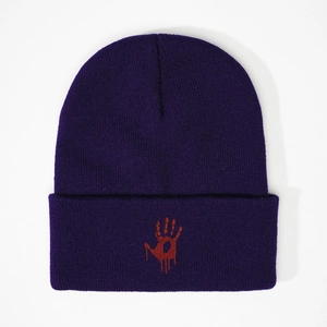 Close-up of deep purple knit beanie featuring a red bloody handprint embroidery design