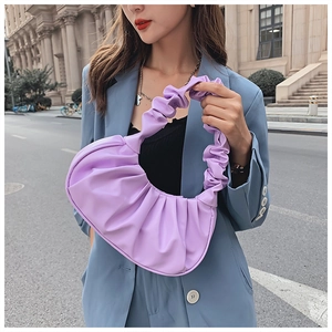 Detail of purple ruched cloud bag with unique gathered handle on a blue blazer outfit