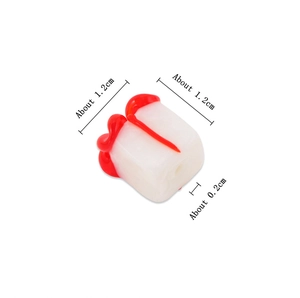 Detailed macro view of 1.2cm cube glass bead with red fluid drip for DIY jewelry