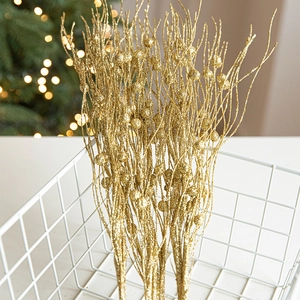 Golden glitter Christmas tree branch decoration with berry accents in warm festive setting