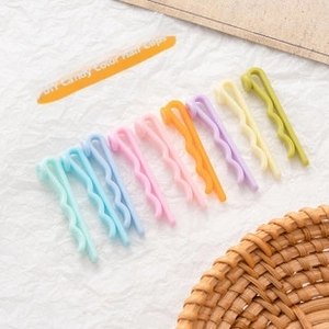 Close-up of matte pastel candy color hairpins set on textured paper for DIY crafts