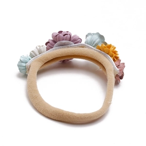 Detail view of colorful fabric flowers on a soft stretch knit headband for babies