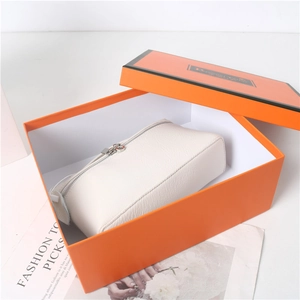 White pebbled leather handbag in a premium orange gift box with silver zipper detail