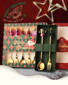 Close-up of golden stainless steel Christmas spoon set with festive cartoon character toppers