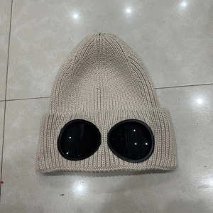Detail of beige knit beanie with integrated protective goggles and thick ear protection