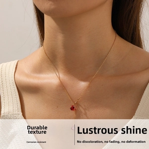 Close-up of heart-shaped red zircon pendant on a gold stainless steel chain necklace