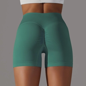 Dettaglio degli shorts da yoga senza cuciture a vita alta con effetto scrunch in verde scuro