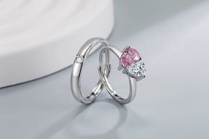 Macro shot of polished silver rings with pink pear-shaped gem and minimalist band details
