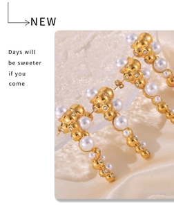 Detailed close-up of 18k gold-plated pearl tassel earrings with shimmering crystals