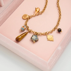 Détail macro du collier vintage à pièces d'or avec œil de tigre et pendentifs