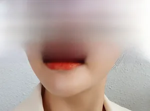 Gros plan d'un rouge à lèvres orange-rouge semi-mat avec une texture lisse détaillée