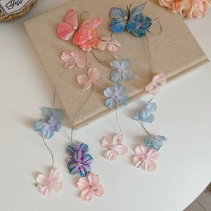 Detail of fabric butterfly and flower hair clips with pearl tassels and pastel colors