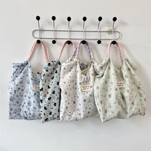 Dettagli di quattro borse tote in seersucker con manici in corda e logo patch