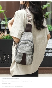 Outdoor shot of a grey canvas crossbody chest bag with detailed jacquard pattern strap